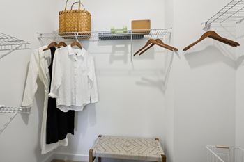 A white shirt is hanging on a hanger in a closet